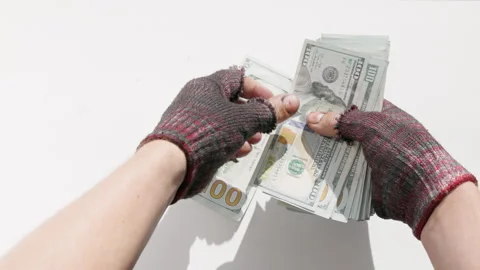 Hands of poor person counting US dollar bills in worn gloves Stock Footage 335364850