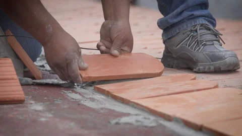 Hands positioning flat clay roof tile during installation Stock-Footage 345695160