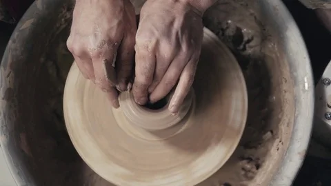 The hands of a potter, creating an earthen jar on the circle, close-up, hands on Stock Footage 78074638