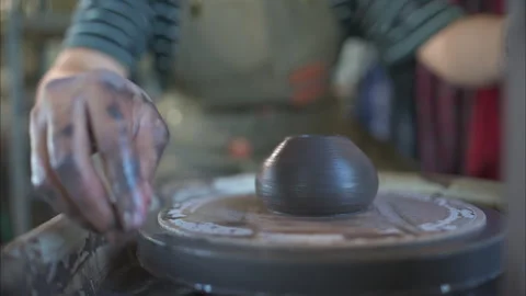 Hands of a potter, creating an earthen jar on the pottery wheel Stock Footage 260314055