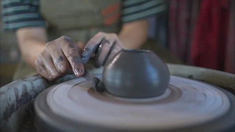 Hands of a potter, creating an earthen jar on the pottery wheel Stock Footage 260314124