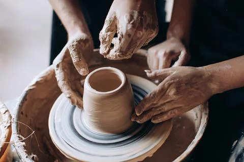 Hands of potter do a clay pot.The view from the top. Stock Photos