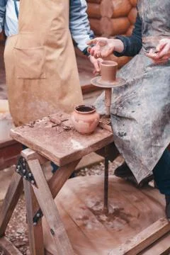 The hands of potter help make pitcher on pottery wheel Stock Photos