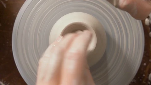 Hands of a Potter make a cavity in the clay Stock Footage 128627878