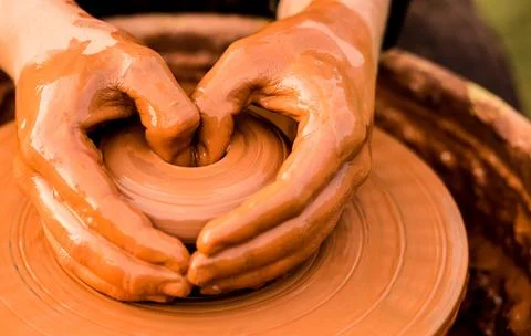 Hands of potter make ceramic jar on pottery wheel outdoor Foto stock