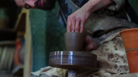 Hands of potter making clay pot on manual potters wheel with foot drive Stock Footage 166365493
