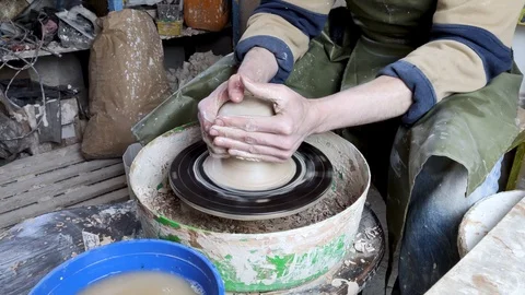 Hands of a potter on a pottery wheel close-up. Old traditional art, handmade, cl Stock-Footage 124490629
