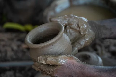 Hands of a potter at work. Potter making ceramic mug on the pottery wheel Stock Photos