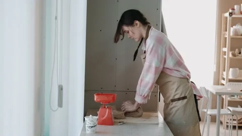 Hands of Potter Worker in Apron preparing and rolling a Piece of Wet Clay on Stock Footage 153093021