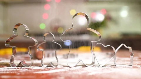 Hands pour flour on the table against the background of dough and iron molds for Stock-Footage 142281397