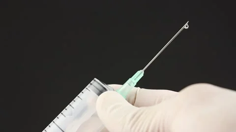 Hands pour out remaining liquid from syringe and disassemble it for disposal Video stock 160053536