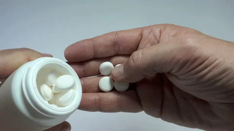 Hands pour pills into the palm of from a white medical jar in 4K Stock Footage