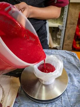 Hands pour red liquid into a plastic bag Stock Photos