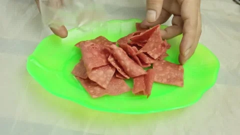 Hands pouring crispy red sweet chips from plastic packaging onto a bright l.. Stock Footage 324820058