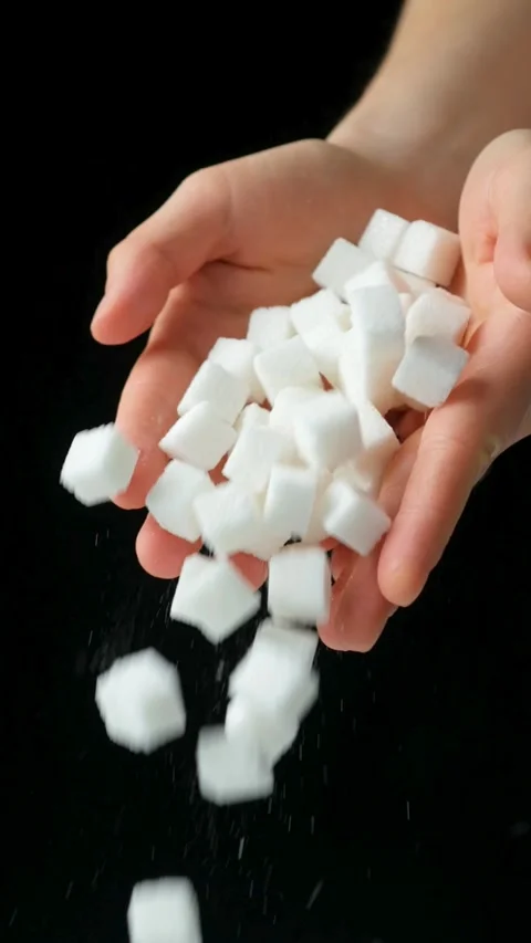 Hands pouring cubes of white pressed beetroot refined sugar, black background Stock Footage 294908852