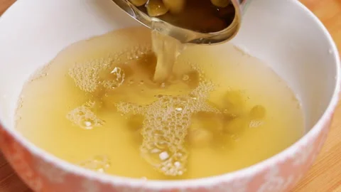 Hands pouring green peas kernels in metal can into a bowl.  Stock Footage 158658228