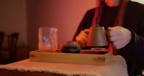 Hands pouring hot tea from a ceramic teapot into Cha Hai... Stock Footage 319883400
