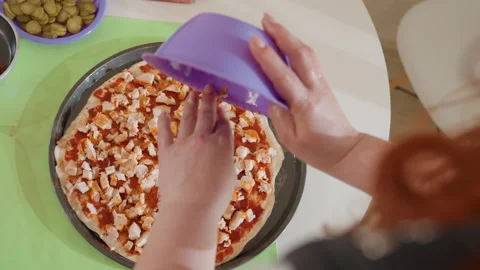 Hands pouring liquid into round baking dish of cubed bread and diced vegetables Video stock 345663373