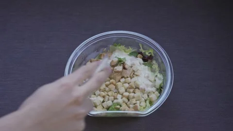 Hands Pouring Sauce into a Fresh Caesar Salad Stock Footage 256223337