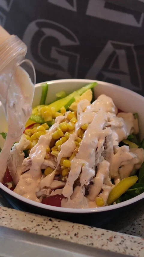 Hands Pouring Sauce into a Fresh Caesar Salad Stock Footage 323450956