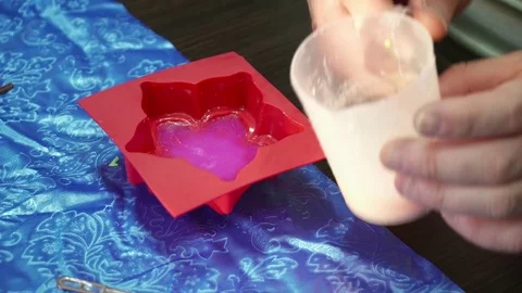 Hands pouring soap base to the flower template Stock Footage 74361415