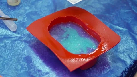 Hands pouring soap base to the red template Stock Footage 74361380