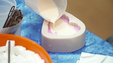 Hands pouring soap base to the template closeup Stock Footage 74361319