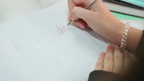 Hands practicing math. Closeup of hands drawing numbers on graph paper notebook Stock Footage 331361006