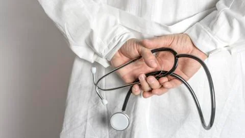 Hands of practitioner with stethoscope. Close up. Stock Photos