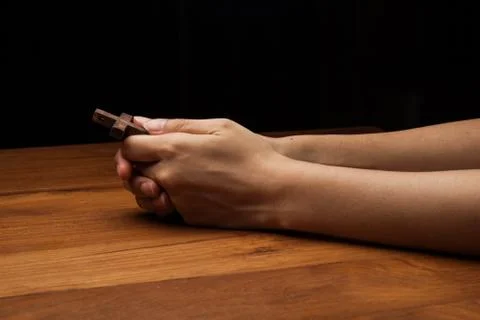 Hands praying with cross Stock Photos