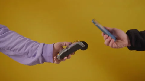 Hands praying to pos device with credit card on yellow background Stock Footage 171590467
