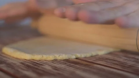 Hands prepare the dough with rolling pin. Chef preparing homemade pasta dough Stock Footage 134057394