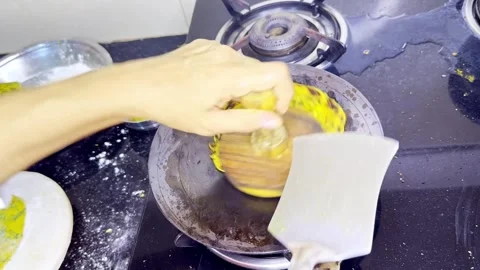 Hands prepare paratha using masher and flipper on griddle Vídeos de archivo 305960850