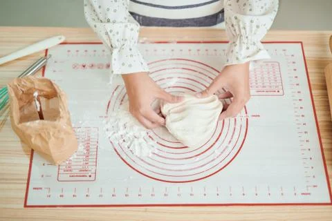 Hands preparing bread dough on wooden table. Stock Photos