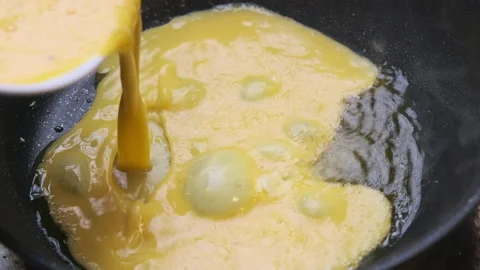 Hands preparing breakfast mix eggs in a bowl for homemade omelettes Stock Footage 172520921
