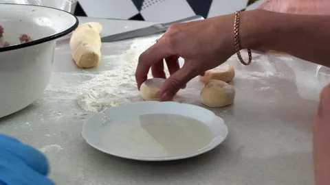 Hands preparing dough on kitchen countertop with flour and rolling pin 스톡 동영상 343515839