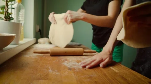 Hands preparing dough on wooden surface while holding dumpling mold. Flattening Video stock 303166768