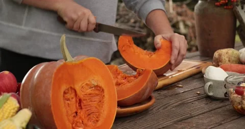 Hands preparing raw pumpkin for cooking and cut into slices Stock Footage 165289428