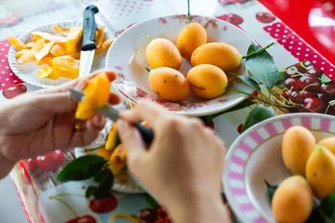 Hands preparing ripe fruit in a kitchen, showcasing vibrant colors and fres.. Stock Photos