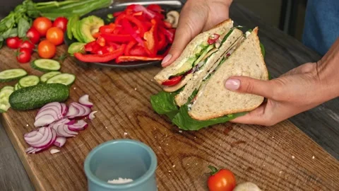 Hands preparing sandwich from full grain bread with avocado and vegetables Stock Footage 160850657