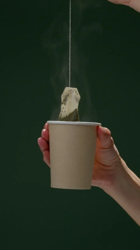 Hands Preparing Tea with Tea Bag in Paper Cup Stock Footage 306925515