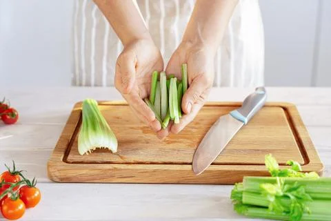 Hands Presenting Cut Celery Sticks for Healthy Recipe Stock Photos
