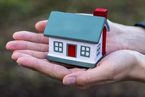Hands presenting a small model of house. Stock Photos