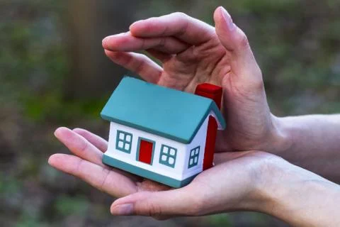 Hands presenting a small model of house. Stock Photos