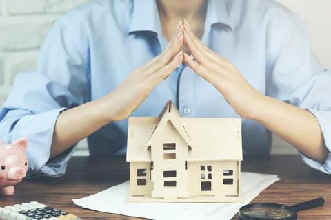 Hands presenting a small model of a house Stock Photos