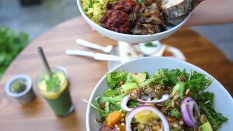 Hands presenting two vegan meals options of buddha bowl and a salad gto the Stock Footage 152017004