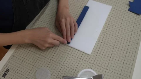 Hands press folded leather edges flat on craft cutting mat Stock Footage 339642838
