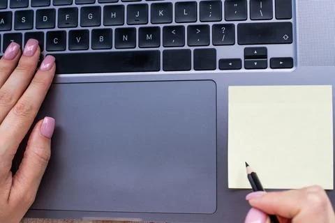 Hands Pressing Computer Keyboard Keys While Writing With Pencil In Notepad... 写真素材