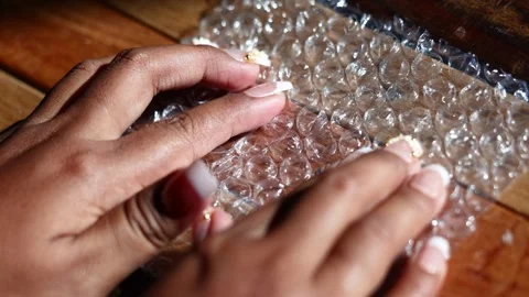 Hands pressing plastic bubble wrap, rapid popping crackle Stock Footage 329479477
