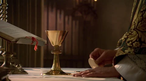 Hands of priest with wafer and chalice during Eucharist Stock Footage 59250013
